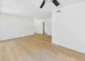 Thumbnail 35 of 50 - A room with a ceiling fan and wooden flooring.