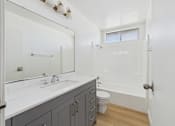 Thumbnail 44 of 50 - A white bathroom with a toilet, sink, and bathtub.