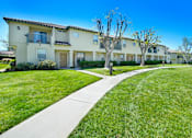 Thumbnail 8 of 11 - the view of an apartment building with a sidewalk and grass