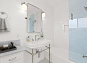 Thumbnail 5 of 17 - a white bathroom with a sink and a tub