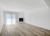 Thumbnail 17 of 85 - an empty living room with white walls and a fireplace