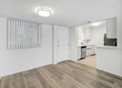 Thumbnail 15 of 85 - an empty living room and kitchen with white walls and wood flooring