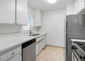 Thumbnail 13 of 85 - an empty kitchen with white cabinets and stainless steel appliances