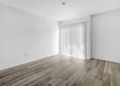 Thumbnail 18 of 85 - an empty living room with white walls and wood floors