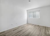Thumbnail 19 of 85 - a bedroom with white walls and wood flooring and a window