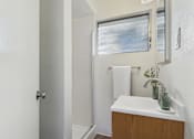 Thumbnail 10 of 23 - A white bathroom with a sink and mirror.