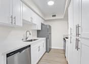 Thumbnail 10 of 18 - a kitchen with white cabinets and stainless steel appliances