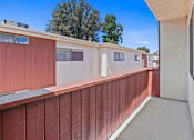 Thumbnail 17 of 18 - a balcony with a red fence and white buildings in the background