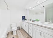 Thumbnail 67 of 127 - A white toilet is in a bathroom with a white sink and white cabinets.