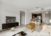 Thumbnail 2 of 45 - a living room with a couch and a kitchen in the background