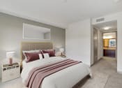 Thumbnail 6 of 45 - a bedroom with a bed and a door to a bathroom