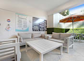 Thumbnail 83 of 95 - A white patio with a table and chairs and a poster on the wall.