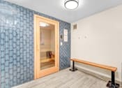 Thumbnail 88 of 95 - A room with a blue tile wall and a wooden bench.