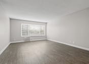 Thumbnail 40 of 64 - an empty living room with wood floors and a window