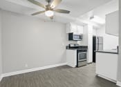 Thumbnail 24 of 64 - the spacious living room and kitchen with stainless steel appliances and a ceiling fan