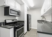 Thumbnail 22 of 64 - a kitchen with stainless steel appliances and white cabinets