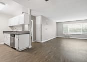 Thumbnail 44 of 64 - an empty living room with a kitchen and a window