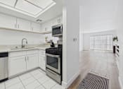 Thumbnail 9 of 29 - A kitchen with white cabinets and a black stove top oven.