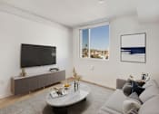 Thumbnail 4 of 31 - A living room with a grey couch, a white coffee table, and a flat screen TV.