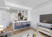 Thumbnail 3 of 31 - A modern living room with a bar area and a television.