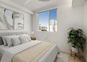 Thumbnail 6 of 31 - A bedroom with a large bed and a potted plant.