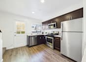 Thumbnail 1 of 34 - A kitchen with a stainless steel refrigerator, oven, and microwave.