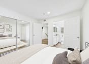 Thumbnail 8 of 34 - A white bedroom with a large bed and a mirrored wardrobe.