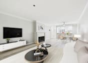 Thumbnail 112 of 127 - A modern living room with a fireplace and a television.