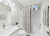 Thumbnail 120 of 127 - A white bathroom with a toilet, sink, and shower.