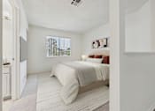 Thumbnail 8 of 115 - A bedroom with a bed, nightstand, and window.