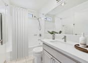 Thumbnail 10 of 115 - A white bathroom with a toilet, sink, and shower.