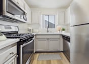 Thumbnail 1 of 115 - A modern kitchen with stainless steel appliances and white cabinetry.