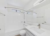 Thumbnail 35 of 115 - A white bathroom with a toilet, sink, and shower.