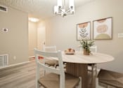 Thumbnail 3 of 33 - A dining room with a round table and chairs.