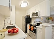 Thumbnail 1 of 33 - A kitchen with white cabinets and black appliances.