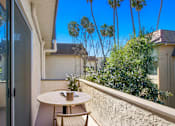 Thumbnail 6 of 33 - A patio with a table and chairs overlooking a garden.