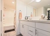 Thumbnail 13 of 33 - A bathroom with a white vanity and a shower with a curtain.
