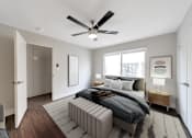 Thumbnail 18 of 19 - A modern bedroom with a large bed and a ceiling fan.
