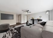 Thumbnail 13 of 19 - A modern living room with a grey sofa and a black and white cowhide rug.