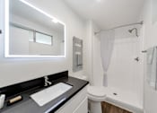Thumbnail 16 of 19 - A modern bathroom with a white toilet and a white shower curtain.