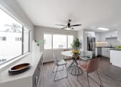 Thumbnail 11 of 19 - A modern kitchen with a dining table and chairs.