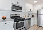 Thumbnail 50 of 66 - a kitchen with white cabinets and stainless steel appliances