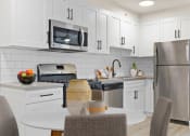 Thumbnail 55 of 66 - a kitchen with white cabinets and stainless steel appliances