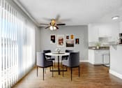 Thumbnail 12 of 19 - A dining room with a table and chairs.