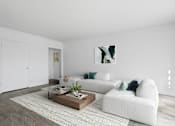 Thumbnail 15 of 26 - A white couch with green pillows sits in a room with a coffee table in front of it.