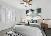 Thumbnail 17 of 26 - A bedroom with a large bed and a ceiling fan.