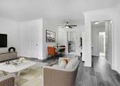 Thumbnail 4 of 26 - A living room with a white couch and a coffee table.