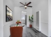 Thumbnail 5 of 26 - A room with a ceiling fan and a painting on the wall.