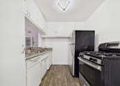 Thumbnail 1 of 32 - A kitchen with a black stove and white cabinets.