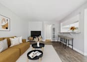 Thumbnail 4 of 32 - A living room with a brown sofa and a coffee table.